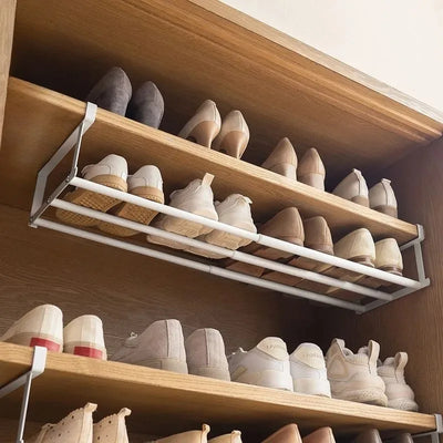 Adjustable telescopic shoe rack with hanging basket for space-saving shoe storage in wardrobe, made of carbon steel.
